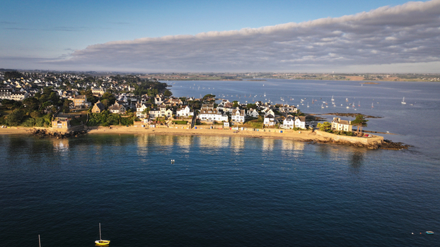 Aerial view of the tranquil shorelines and the quaint architecture where the land meets the sea under a serene sky Carantec Brittany France. Aerial view of the tranquil shorelines and the quaint architecture where the land meets the sea under a serene sky Carantec Brittany France.