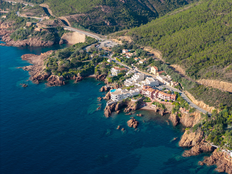 Aerial view of Le Trayas a coastal village with red rock cliffs Mediterranean sea and lush green hills in Saint Raphael Provence Alpes Cote d Azur France. Aerial view of Le Trayas a coastal village with red rock cliffs Mediterranean sea and lush green hills in Saint Raphael Provence Alpes Cote d Azur France.