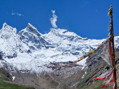 View of prayer flags fluttering in the wind with the snow capped peaks of the Himalayas in the background along the Penzi La road in Zanskar Ladakh India.