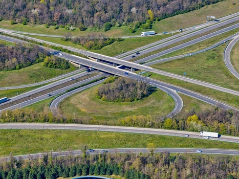 Aerial view of a sprawling highway interchange cutting through verdant fields and forests the concrete and asphalt contrasting with nature s palette Sausheim Grand Est France.