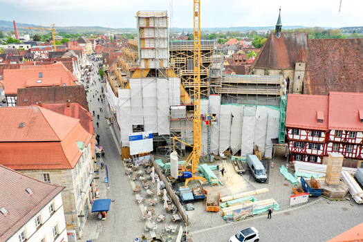 Aerial view of Rathaus Forchheim under renovation with scaffolding and a yellow crane among historic red tiled rooftops in Forchheim Bayern Germany.