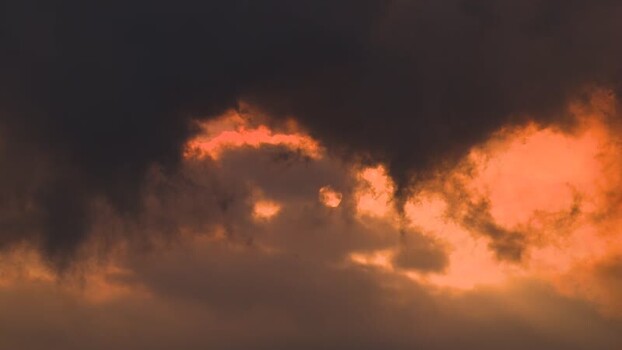 View of sun peeking through dark clouds United States.
