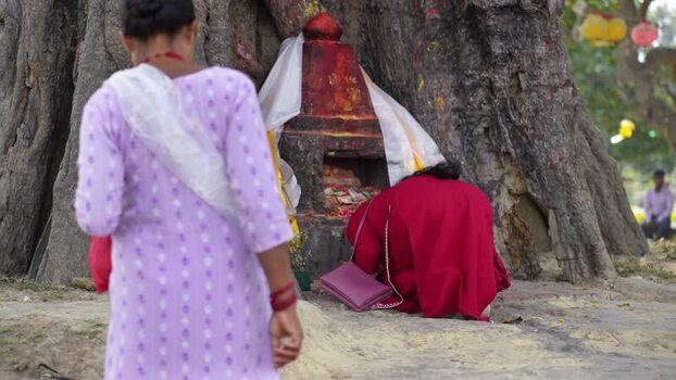 View of a woman praying at a sacred shrine in Lumbini Nepal.