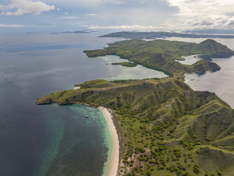 Aerial view of Pink Beach with its unique pink sand turquoise waters and surrounding lush green hills in East Nusa Tenggara Indonesia. Aerial view of Pink Beach with its unique pink sand turquoise waters and surrounding lush green hills in East Nusa Tenggara Indonesia.