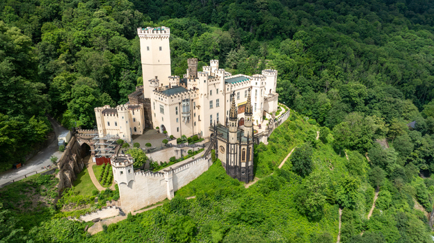 Aerial view of Stolzenfels Castle featuring white towers and Gothic Revival architecture surrounded by lush green forests of the Rhine Valley Koblenz Rheinland Pfalz Germany. Aerial view of Stolzenfels Castle featuring white towers and Gothic Revival architecture surrounded by lush green forests of the Rhine Valley Koblenz Rheinland Pfalz Germany.