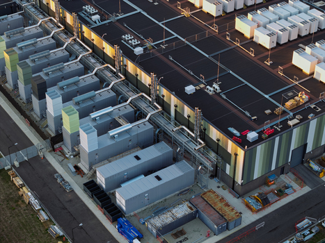Aerial view of a data center facility featuring industrial cooling units complex piping systems and rooftop equipment in the United Kingdom. Aerial view of a data center facility featuring industrial cooling units complex piping systems and rooftop equipment in the United Kingdom.