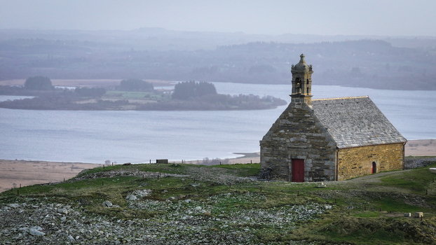 Aerial view of Mont Saint Michel de Brasparts chapel on a rocky hilltop overlooking the misty Lac de Saint Michel and the surrounding moorland Saint Rivoal Bretagne France. Aerial view of Mont Saint Michel de Brasparts chapel on a rocky hilltop overlooking the misty Lac de Saint Michel and the surrounding moorland Saint Rivoal Bretagne France.
