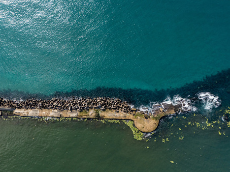 Aerial view of the breakwater at the mouth of the Rio Ozama with concrete tetrapods and a circular pier structure in Santo Domingo Santo Domingo Dominican Republic.