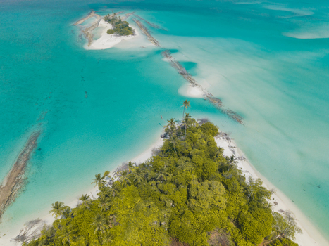 Aerial view of pristine turquoise waters embrace lush green islands connected by a sandy causeway creating a serene tropical paradise Thuraakunu Thiladhunmathee Uthuruburi Maldives. Aerial view of pristine turquoise waters embrace lush green islands connected by a sandy causeway creating a serene tropical paradise Thuraakunu Thiladhunmathee Uthuruburi Maldives.