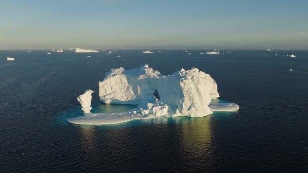 Aerial view of arch iceberg floating in the ocean Greenland. Aerial view of arch iceberg floating in the ocean Greenland.