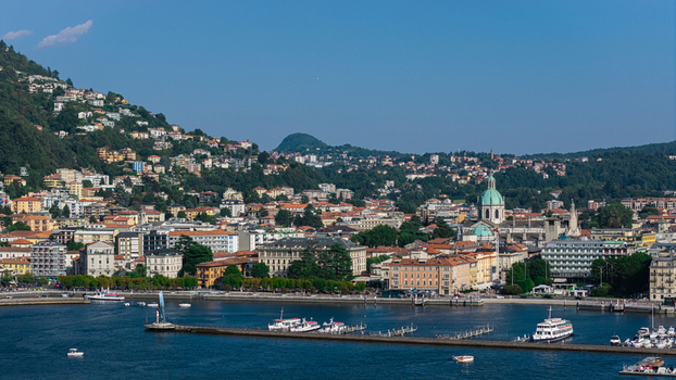 Aerial view of the historic city of Como with its cathedral dome waterfront promenade and boats on Lake Como in Como Lombardy Italy.