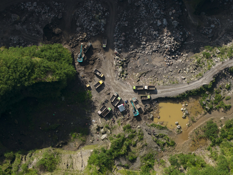 Aerial view of Tambang Pasir Merapi Kali Gendol Sand Mine with excavators loading trucks on a dirt road by rocky terrain Kecamatan Cangkringan Daerah Istimewa Yogya Indonesia. Aerial view of Tambang Pasir Merapi Kali Gendol Sand Mine with excavators loading trucks on a dirt road by rocky terrain Kecamatan Cangkringan Daerah Istimewa Yogya Indonesia.