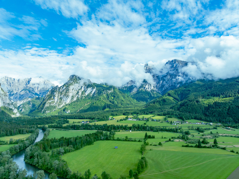 Aerial view of Nationalpark Gesause with winding rivers green valleys scattered houses and dramatic mountain peaks such as Admonter Reichenstein and Hochtor in Admont Steiermark Austria.