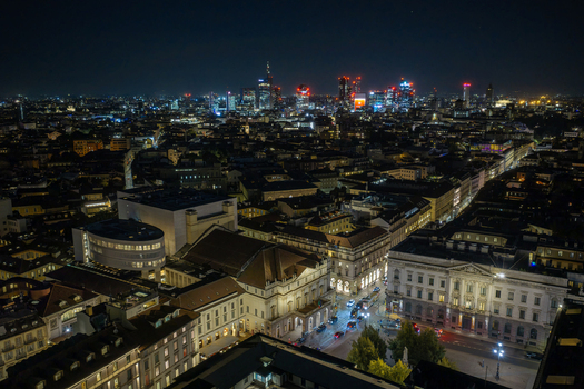 Milan Italy 23 September 2026 Aerial view of the historic Teatro alla Scala and the illuminated modern skyline of Milan at night featuring glowing skyscrapers and dense urban architecture. Milan Italy 23 September 2026 Aerial view of the historic Teatro alla Scala and the illuminated modern skyline of Milan at night featuring glowing skyscrapers and dense urban architecture.