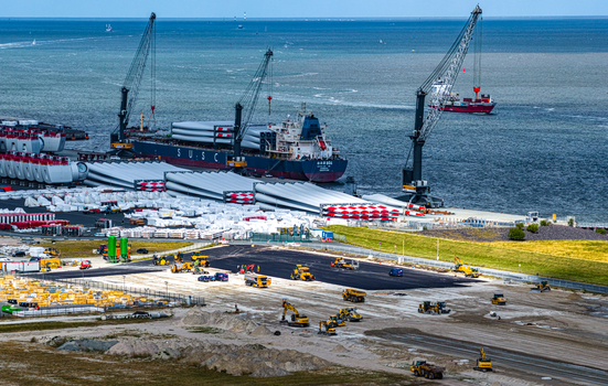 Aerial view of the Siemens Gamesa Renewable Energy facility at the port with wind turbine blades cargo ships and construction machinery in Cuxhaven Niedersachsen Germany.