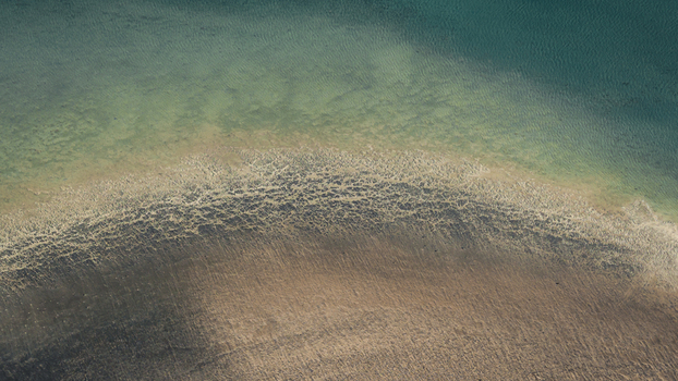 Aerial view of the intricate sand patterns and turquoise blue water along the coastline in Denham Western Australia Australia. Aerial view of the intricate sand patterns and turquoise blue water along the coastline in Denham Western Australia Australia.