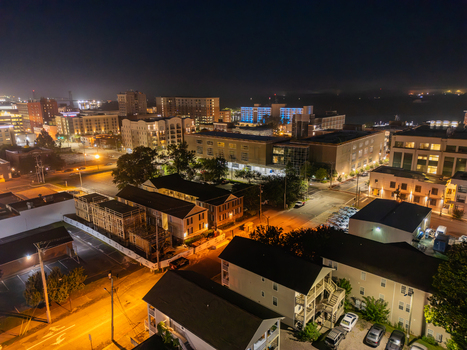 Aerial view of the illuminated cityscape of Wilmington at night featuring residential buildings street lights and urban infrastructure in Wilmington North Carolina United States.