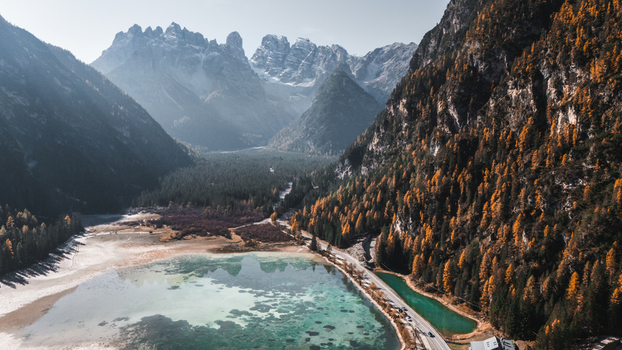 Aerial view of Durrensee lake with turquoise water surrounded by autumn colored forests and the rugged peaks of the Dolomites in Toblach Trentino Alto Adige Italy. Aerial view of Durrensee lake with turquoise water surrounded by autumn colored forests and the rugged peaks of the Dolomites in Toblach Trentino Alto Adige Italy.