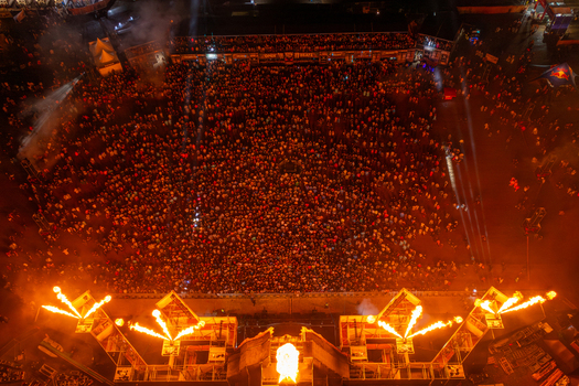 Herzogenaurach Germany 26 July 2025 Aerial view of the Open Beatz Festival with a massive crowd illuminated by stage lights and pyrotechnic flames at night.