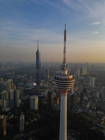 Aerial view of the Menara Kuala Lumpur tower and Merdeka 118 skyscraper rising above the urban skyline during golden hour in Kuala Lumpur Federal Territory of Malaysia. Aerial view of the Menara Kuala Lumpur tower and Merdeka 118 skyscraper rising above the urban skyline during golden hour in Kuala Lumpur Federal Territory of Malaysia.