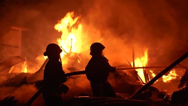 View of firefighters battling a massive blaze at night Bangladesh. View of firefighters battling a massive blaze at night Bangladesh.