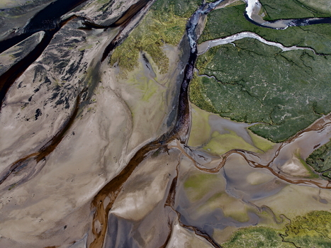 Aerial view of the winding water channels and sandy banks of Findhorn Bay surrounded by green marshland in Findhorn Scotland United Kingdom. Aerial view of the winding water channels and sandy banks of Findhorn Bay surrounded by green marshland in Findhorn Scotland United Kingdom.