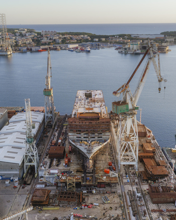 Aerial view of the Pola Port shipyard with a large ship under construction and industrial cranes in Pula Istarska zupanija Croatia. Aerial view of the Pola Port shipyard with a large ship under construction and industrial cranes in Pula Istarska zupanija Croatia.