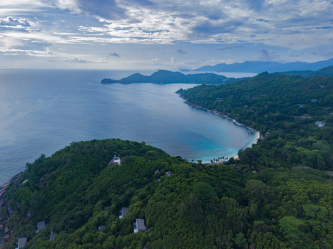 Aerial view of the coastline where the lush green vegetation meets the turquoise waters under a vast sky Quatre Bornes Mahe Island Seychelles. Aerial view of the coastline where the lush green vegetation meets the turquoise waters under a vast sky Quatre Bornes Mahe Island Seychelles.