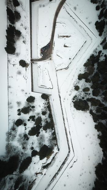 Aerial view of the snow covered geometric ramparts of Le Fort des Rousses surrounded by pine trees in winter Les Rousses Bourgogne Franche Comte France.