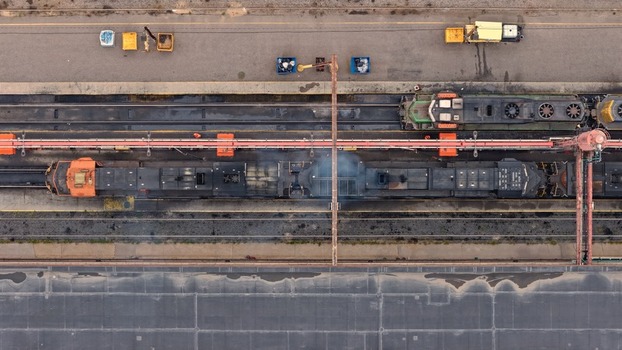 Aerial view of a freight train idling at a rail yard with locomotives tracks and industrial equipment in Denver Colorado United States. Aerial view of a freight train idling at a rail yard with locomotives tracks and industrial equipment in Denver Colorado United States.