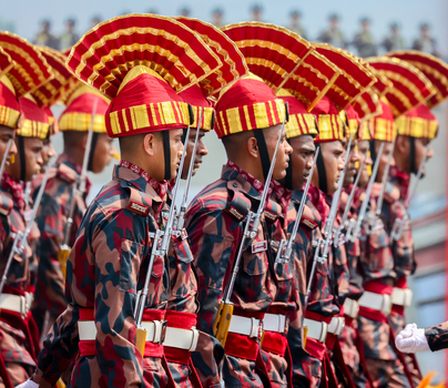 Dhaka Bangladesh 25 March 2026 View of uniformed guards with red and gold headdresses marching in unison their rifles gleaming under the bright sky.