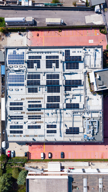 Aerial view of an industrial building roof covered with solar panels and ventilation systems in a parking area in Milan Lombardy Italy. Aerial view of an industrial building roof covered with solar panels and ventilation systems in a parking area in Milan Lombardy Italy.