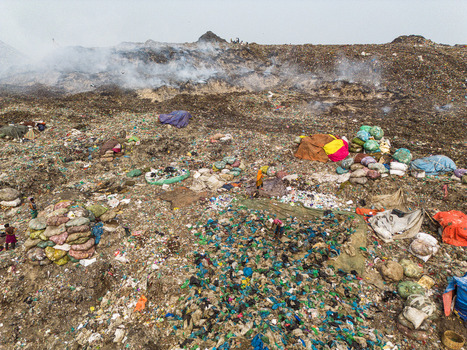 Aminbazar Bangladesh 26 January 2025 Aerial view of the Aminbazar landfill with workers scavenging among vast piles of waste and smoke rising from burning trash under a hazy sky. Aminbazar Bangladesh 26 January 2025 Aerial view of the Aminbazar landfill with workers scavenging among vast piles of waste and smoke rising from burning trash under a hazy sky.
