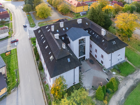 Aerial view of a grand building with a dark roof and light walls surrounded by lush greenery bathed in the soft glow of the afternoon sun Mosovce Zilina Region Slovakia. Aerial view of a grand building with a dark roof and light walls surrounded by lush greenery bathed in the soft glow of the afternoon sun Mosovce Zilina Region Slovakia.