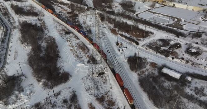 Aerial view of a freight train passing a power line tower United States. Aerial view of a freight train passing a power line tower United States.