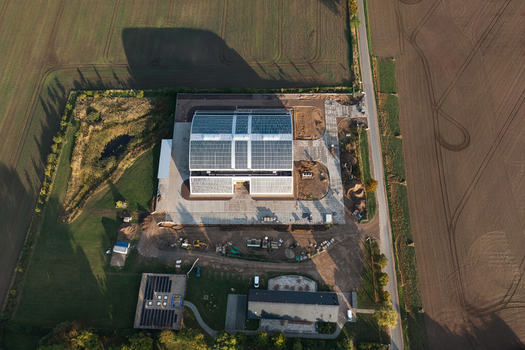 Aerial view of a modern building with solar panels surrounded by agricultural fields and rural landscape Uckermark Brandenburg Germany. Aerial view of a modern building with solar panels surrounded by agricultural fields and rural landscape Uckermark Brandenburg Germany.