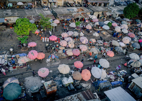 Aerial view of Panteka Market with colorful umbrellas and people walking between busy stalls in Kaduna Kaduna Nigeria. Aerial view of Panteka Market with colorful umbrellas and people walking between busy stalls in Kaduna Kaduna Nigeria.