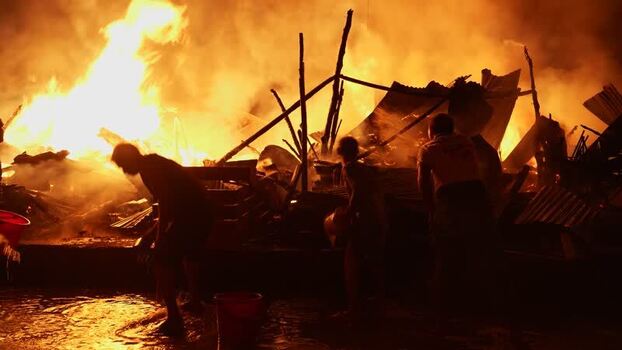 View of people fighting a large fire at night Bangladesh. View of people fighting a large fire at night Bangladesh.