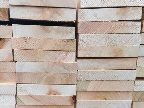 View of neatly stacked wooden planks in a timber yard showcasing natural wood grain textures and orderly construction materials in Pretoria Gauteng South Africa.