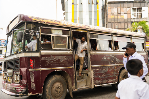 Sri Lanka 07 January 2026 View of a Shyam Super Express maroon public transport bus with passengers and urban buildings in the background.