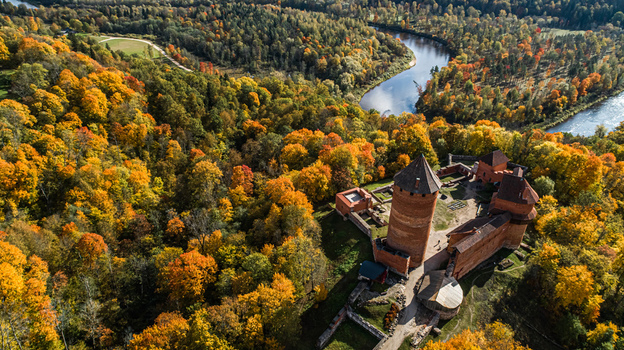 Aerial view of Turaida Castle surrounded by vibrant autumn forests and the winding Gauja River in Sigulda Sigulda Municipality Latvia. Aerial view of Turaida Castle surrounded by vibrant autumn forests and the winding Gauja River in Sigulda Sigulda Municipality Latvia.