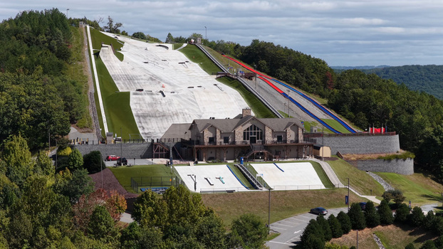 Aerial view of the Liberty Mountain Snowflex Centre featuring synthetic ski slopes a lodge building and surrounding forest in Lynchburg Virginia United States. Aerial view of the Liberty Mountain Snowflex Centre featuring synthetic ski slopes a lodge building and surrounding forest in Lynchburg Virginia United States.