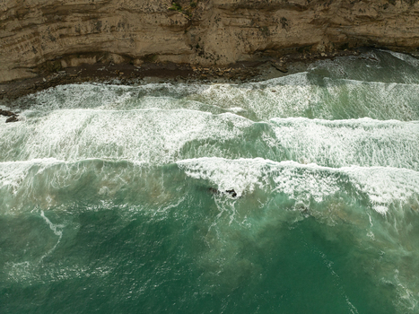 Aerial view of La Jolla Cove with turquoise ocean waves crashing against steep rocky cliffs and white sea foam in San Diego California United States. Aerial view of La Jolla Cove with turquoise ocean waves crashing against steep rocky cliffs and white sea foam in San Diego California United States.