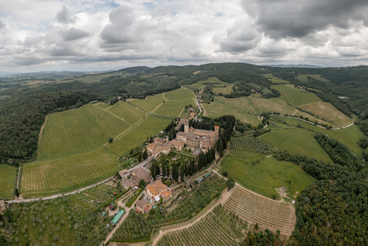 Aerial view of the historic Abbey of Passignano surrounded by lush vineyards cypress trees and the rolling hills of the Tuscan countryside in Passignano Toscana Italy. Aerial view of the historic Abbey of Passignano surrounded by lush vineyards cypress trees and the rolling hills of the Tuscan countryside in Passignano Toscana Italy.