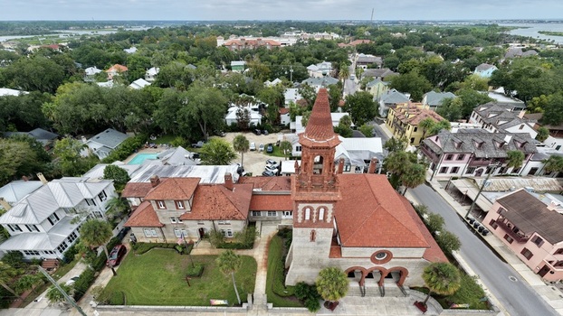 Aerial view of Grace United Methodist Church with its distinctive red tiled roof and bell tower surrounded by historic buildings and lush trees in St. Augustine Florida United States. Aerial view of Grace United Methodist Church with its distinctive red tiled roof and bell tower surrounded by historic buildings and lush trees in St. Augustine Florida United States.