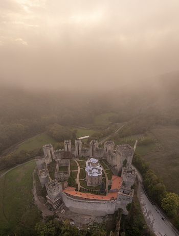 Aerial view of Manasija Monastery surrounded by fortified walls and lush greenery in the misty landscape of Despotovac Pomoravski okrug Serbia.