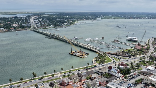 Aerial view of the Bridge of Lions with a construction barge and crane in the Matanzas River surrounded by marinas and historic buildings in St. Augustine Florida United States. Aerial view of the Bridge of Lions with a construction barge and crane in the Matanzas River surrounded by marinas and historic buildings in St. Augustine Florida United States.