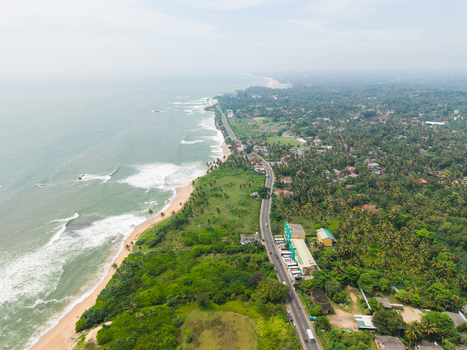 Aerial view of the scenic coastline with a winding road running alongside sandy beaches and lush tropical vegetation Galle Southern Province Sri Lanka. Aerial view of the scenic coastline with a winding road running alongside sandy beaches and lush tropical vegetation Galle Southern Province Sri Lanka.