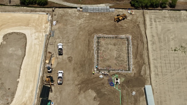 Aerial view of the construction site at Foundry Lane featuring foundation excavation heavy machinery and workers on site in World Golf Village Florida United States.