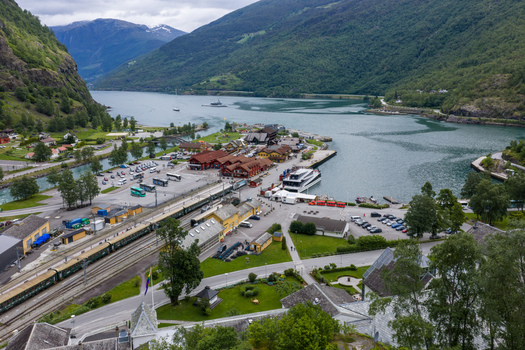 Aerial view of the harbor and train station in Flam surrounded by lush mountains and the fjord in Flam Vestland Norway. Aerial view of the harbor and train station in Flam surrounded by lush mountains and the fjord in Flam Vestland Norway.